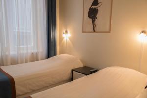 阿姆斯特丹多利亚酒店的酒店客房设有两张床和窗户。