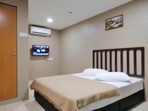 Pasir MasHotel Nawar的卧室配有一张床,墙上配有电视。