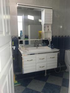 贝贾亚Super appartement de luxe T4 a la ville de Bejaia的一间带水槽、镜子和卫生间的浴室