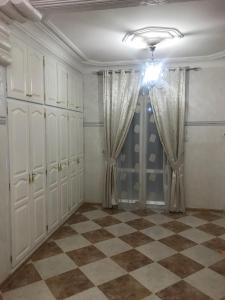 贝贾亚Super appartement de luxe T4 a la ville de Bejaia的一间设有白色橱柜和 ⁇ 格地板的客房