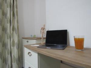 剑桥The Tas Suites - Tas Accommodations的一张桌子上的笔记本电脑,上面放着一杯啤酒