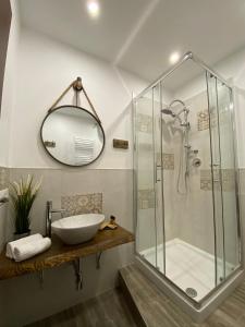 蒂沃利La Corte Segreta Tivoli的带淋浴、盥洗盆和镜子的浴室