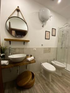 蒂沃利La Corte Segreta Tivoli的一间带卫生间、水槽和镜子的浴室