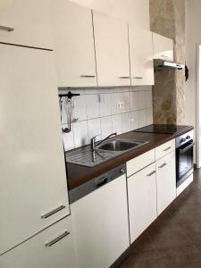 特罗吉尔纳尼托公寓 的厨房配有白色橱柜和水槽