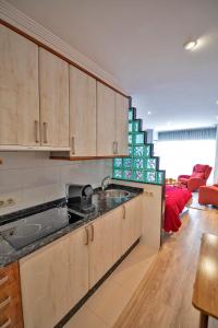 维戈Loft Vigo的厨房配有木制橱柜和红色沙发
