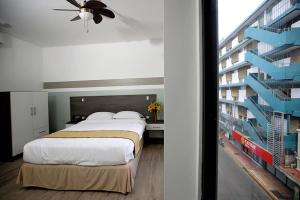 圣何塞Hotel Cultura Plaza的一间带大床的卧室和一座建筑