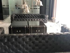 布宜诺斯艾利斯Lumiere Puerto Madero的一组黑色皮沙发,带手提箱