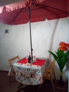 布杰鲁AL MARE, AL SOLE, SI', ma nella CASA DEL MINATORE的一张桌子,上面有雨伞和一瓶葡萄酒