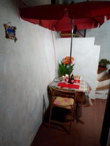 布杰鲁AL MARE, AL SOLE, SI', ma nella CASA DEL MINATORE的一张桌子和一把红色雨伞