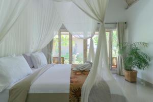 珀尼达岛Angels Bungalow Nusa Penida的一间卧室配有一张带天蓬的白色床