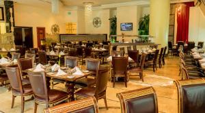 迪拜阿尔巴沙怡东大酒店的一间带桌椅的餐厅和一间酒吧