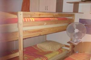 圣特罗佩Mobilhome sur camping le kontiki **** ramatuelle的一张木制双层床,配有风扇和枕头