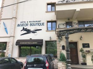 奥托佩尼Hotel Aviator Boutique的前面有汽车停放的建筑