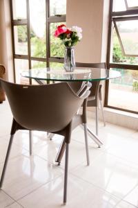 哈拉雷Villa Prince的玻璃桌和花瓶椅子