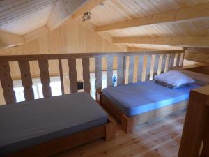 Serrières-sur-AinCabanes et Lodges du Belvedere的木制阁楼上的卧室配有两张床