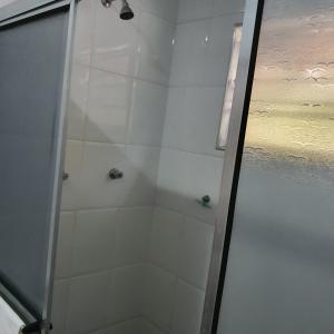 卡纳内亚Pousada Recanto do Morro的浴室里设有玻璃门淋浴