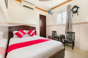 胡志明市NGAN HA Hotel的一间卧室设有一张床、一个窗口和一个时钟