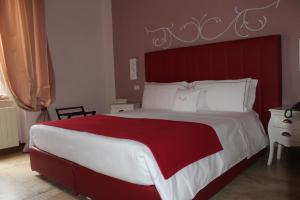 克罗托内美露住宿加早餐旅馆的一间卧室配有一张大床和红色床头板