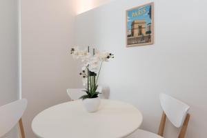 巴黎Villa Poncelet的一张白色的桌子,上面有花瓶