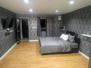 芭堤雅市中心GW guesthouse的一间卧室配有一张床和一台电视