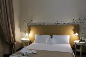 克罗托内美露住宿加早餐旅馆的卧室配有一张带两张桌子的大型白色床