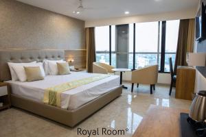 孟买Hotel Grace Galaxy的酒店客房设有一张大床和一张书桌。