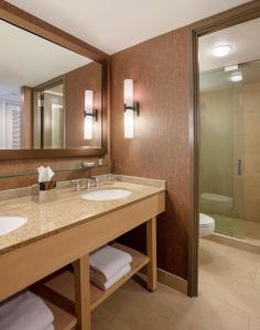 奥克布鲁克Hyatt Lodge Oak Brook Chicago的浴室设有2个水槽、卫生间和镜子。