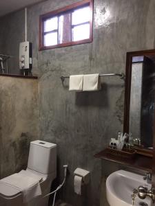 乌隆他尼Tara Beach Resort Udonthani的一间带卫生间、水槽和窗户的浴室