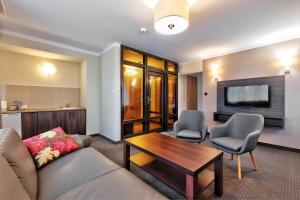比亚韦斯托克莱斯尼酒店的客厅配有沙发、椅子和电视