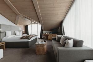 利维尼奥Eco & Wellness Boutique Hotel Sonne的一间卧室配有一张床和一张沙发