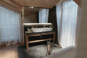 利维尼奥Eco & Wellness Boutique Hotel Sonne的一间带水槽和镜子的浴室
