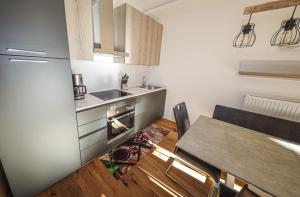 巴德小基希海姆Appartementhaus Römerhof Superior的厨房配有桌子、水槽和冰箱