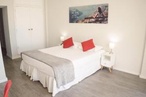 里约热内卢CLH Suites Domingos Ferreira的卧室配有带红色枕头的大型白色床