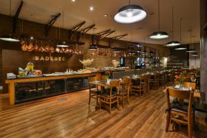 圣保罗Radisson Vila Olimpia Sao Paulo的一间带木桌椅的餐厅和一间酒吧