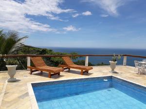 伊利亚贝拉Casa das Ilhas的一个带两把椅子的庭院和一个游泳池
