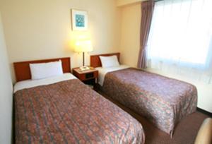 郡山郡山星级酒店的酒店客房设有两张床和窗户。