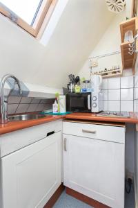 鹿特丹Residentie Blijdorp的厨房配有白色橱柜和水槽