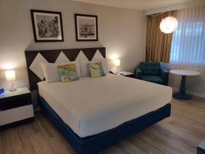 圣地亚哥基恩斯旅馆的卧室配有一张白色大床和一张蓝色椅子