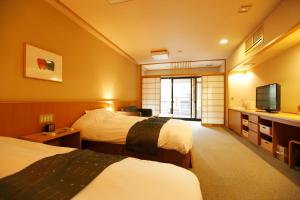 箱根箱根小涌谷温泉水之音传统日式旅馆的酒店客房设有两张床和电视。