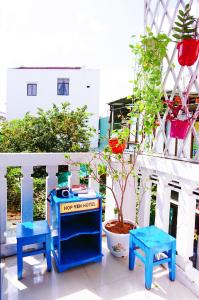 会安Hi Hợp Yến Homestay的阳台上的两把蓝色长椅和盆栽植物