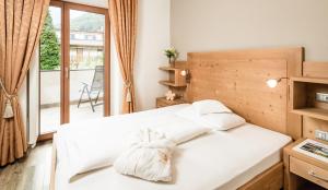 拉古多Nutzhof - Mediterran Flair Hotel的一间带2张白色床的卧室和一个阳台
