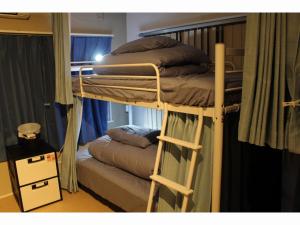 鹿儿岛Shiroyama Guesthouse Banvina的客房内的双层床配有两张床垫