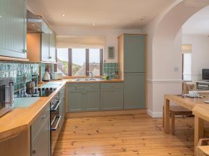 霍普湾2 Armada House的铺有木地板的厨房配有绿色橱柜