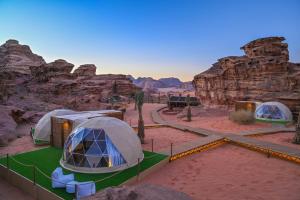 瓦迪拉姆Palmera Camp Wadi Rum的沙漠中一些岩石附近的一组帐篷