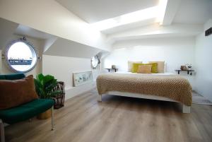 阿姆斯特丹Eco HouseBoat的一间卧室配有一张床和一把绿色椅子