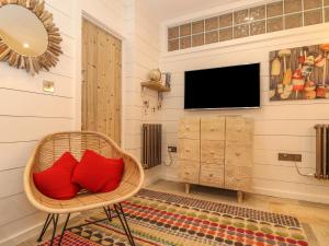 廷塔杰尔Beach Hut的客厅配有带红色枕头的柳条椅