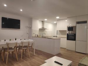 安道尔城SUITEDREAMS - Pollancre 23的白色的厨房配有桌椅和柜台。