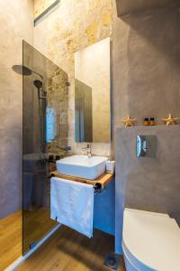 干尼亚Aelios Design Hotel的一间带水槽、卫生间和镜子的浴室