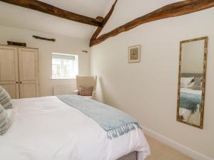 斯基普顿Croft Cottage的一间卧室配有一张床和镜子