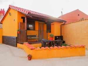 坎塔洛哈斯Apartamentos Rurales El Casarejo的黄色的房子,配有桌子和栅栏